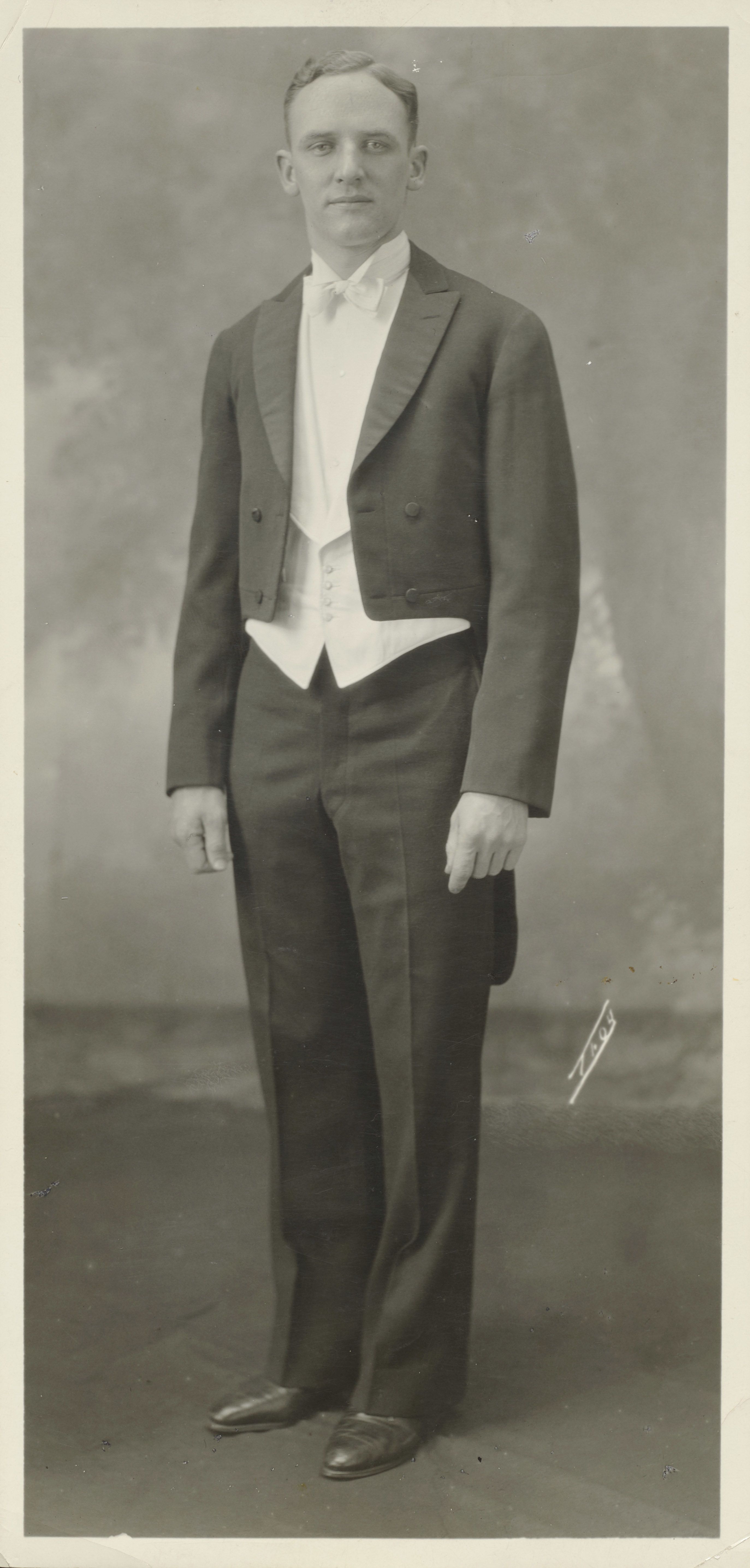 Man wearing a very formal suit and bow tie.