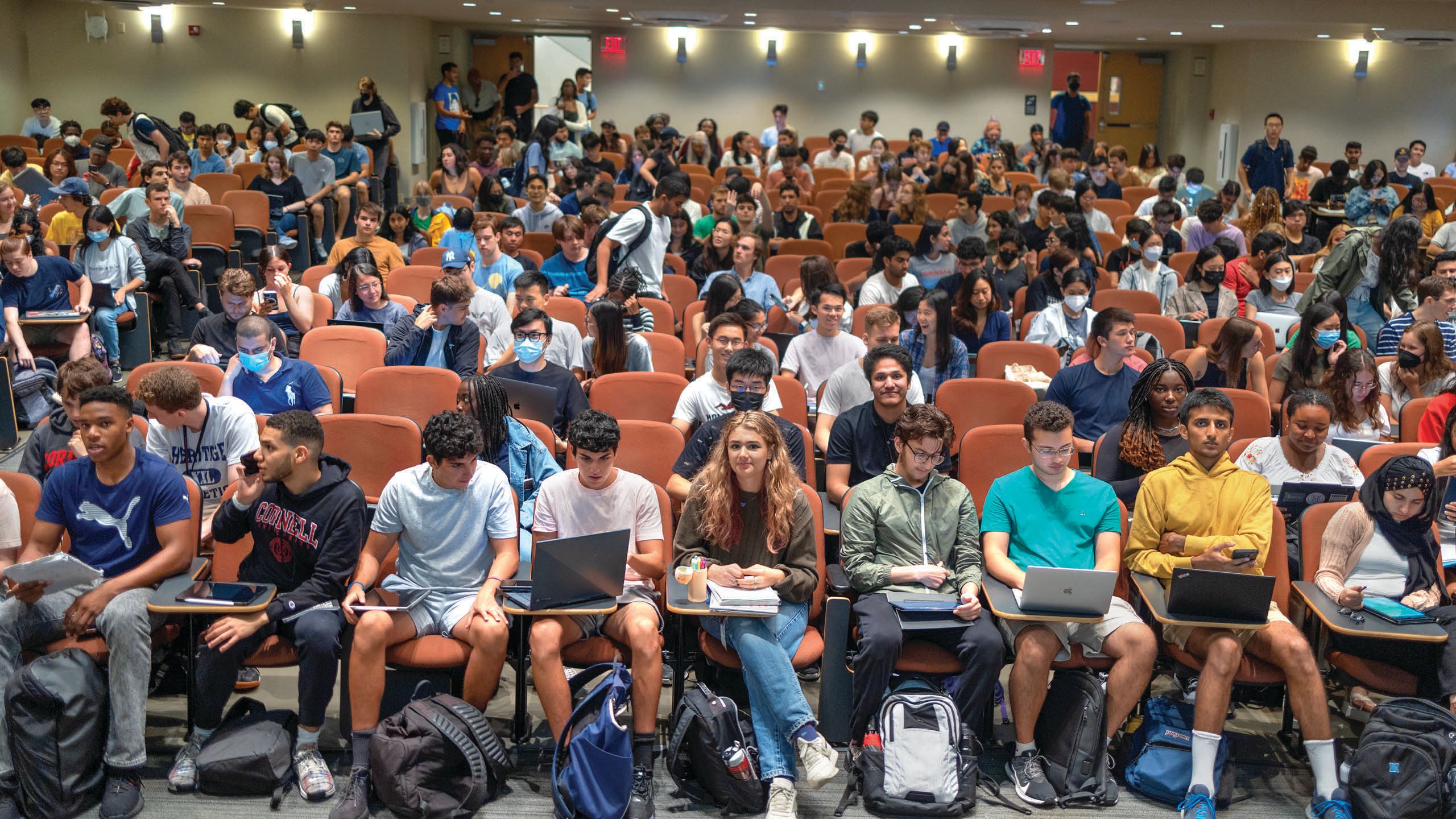 Students sitting in a tiered classroom.