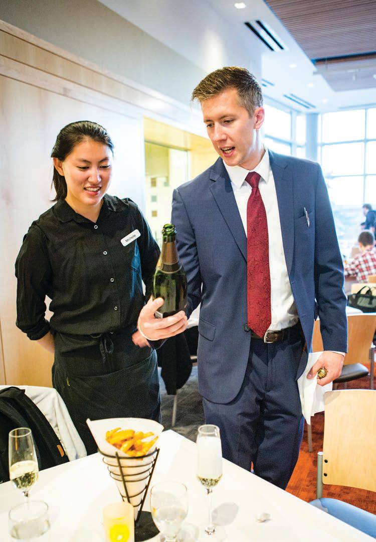 Lecturer Christopher Gaulke holds a bottle with Michelle (Chuanwen) Chen ’17.