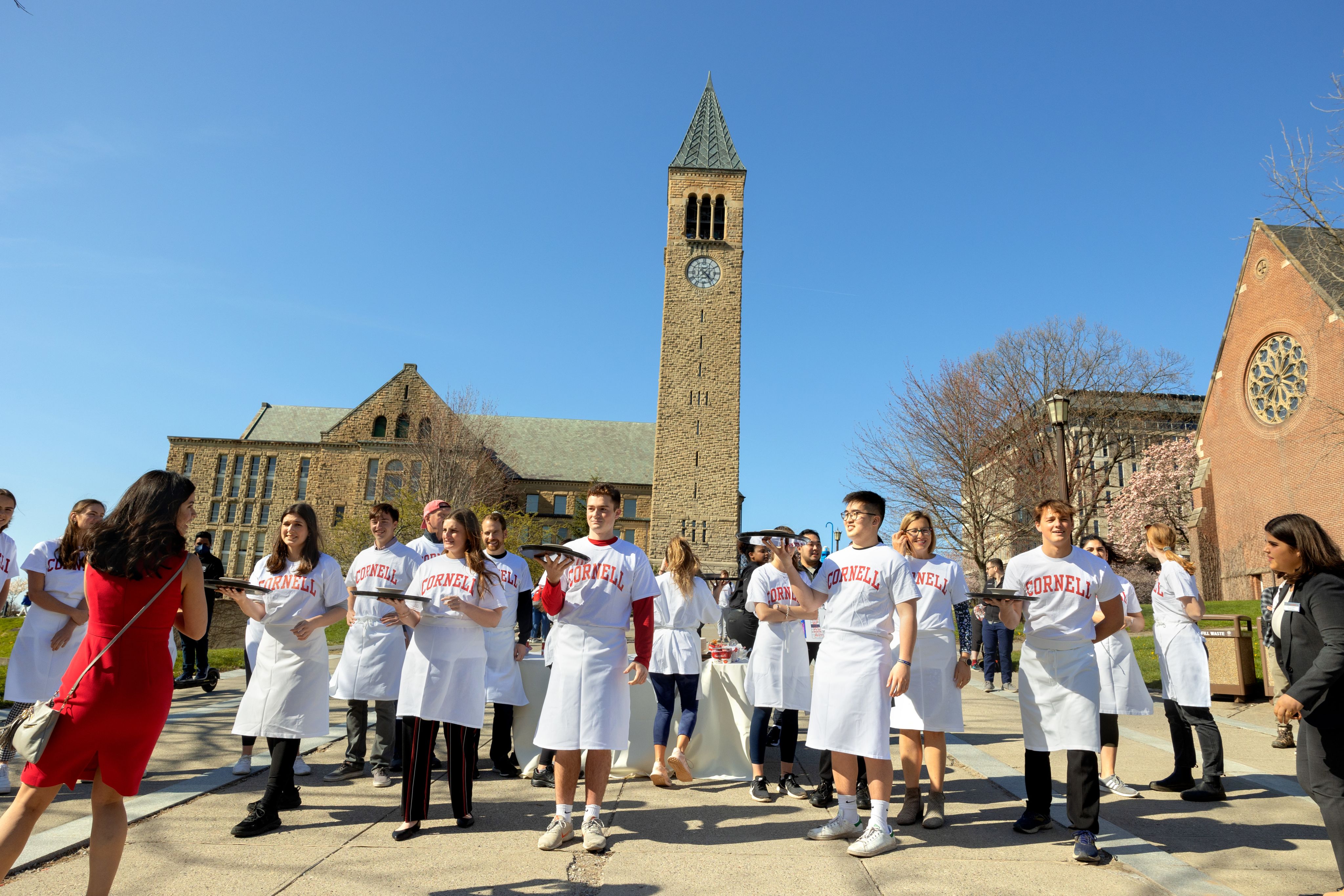 Students wear white Cornell t-shirts in front of McGraw tower waiting for the waiter derby to start.