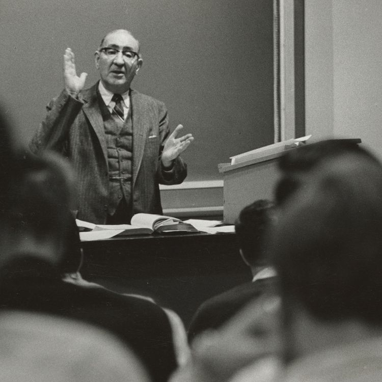 Professor John H. Sherry standing at a podium in front of a classroom..