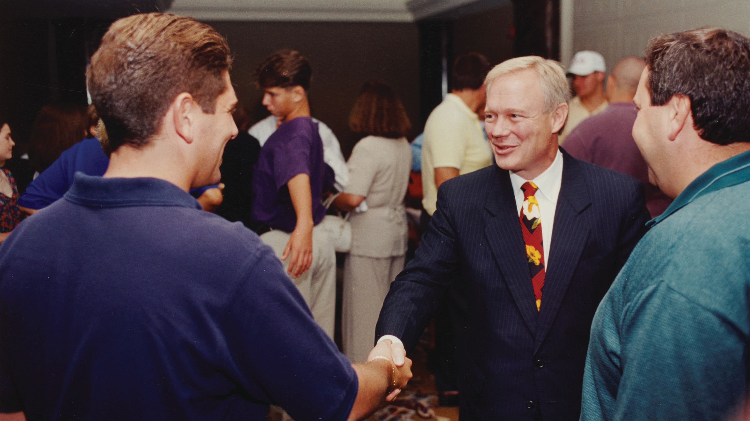 Dean David Dittman in a suit shaking hands.