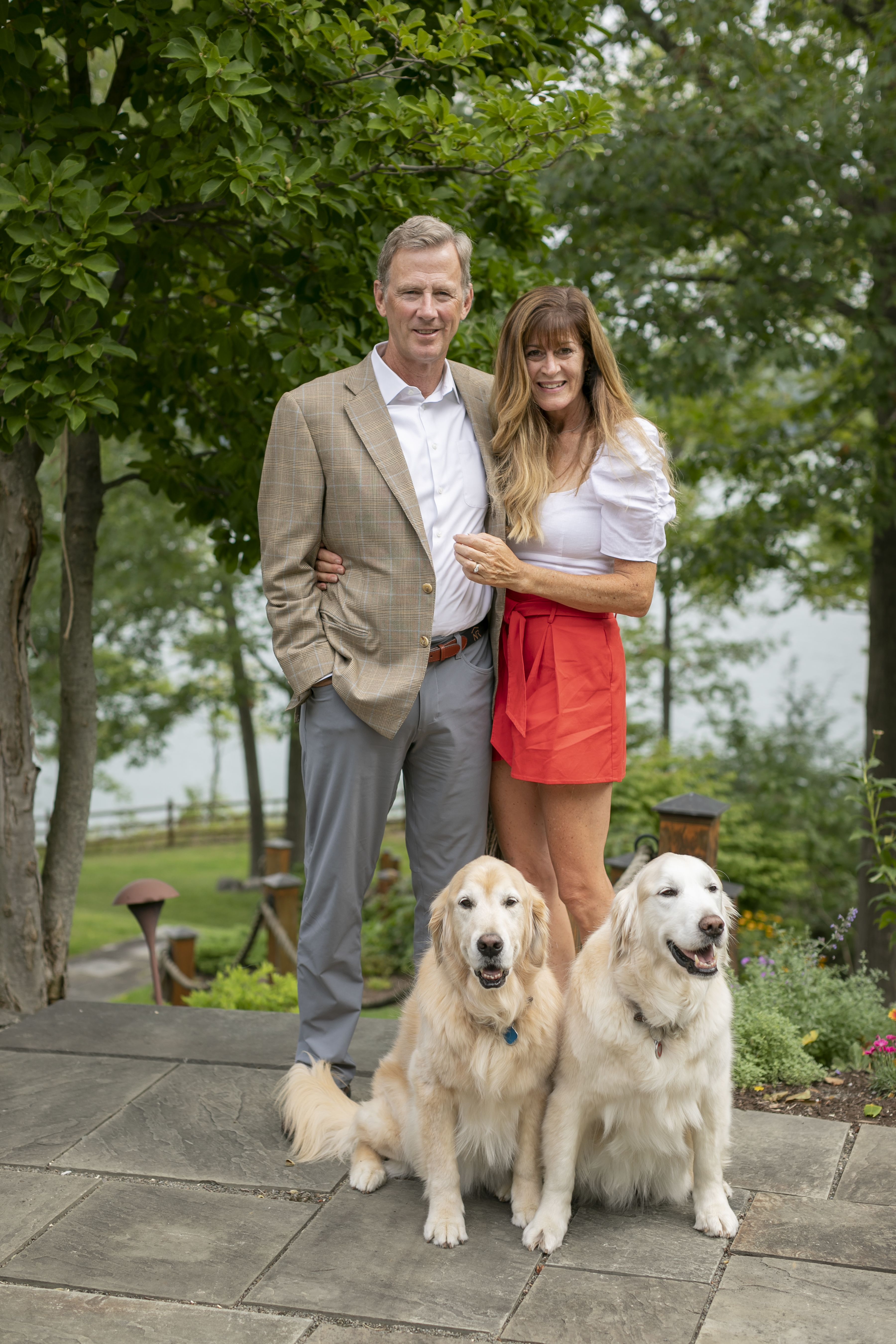 Peter and Stephanie Nolan standing outside their home with their two dogs Maci and Bailey at their feet.